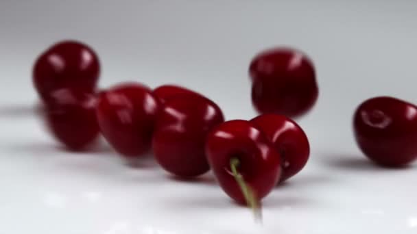 Cerezas rojas cayendo sobre la mesa — Vídeo de stock