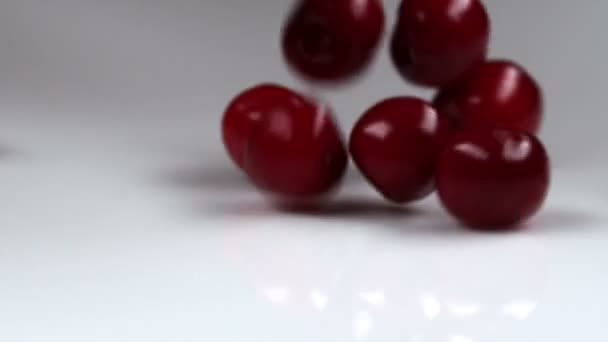 Cerises rouges tombant sur la table — Video