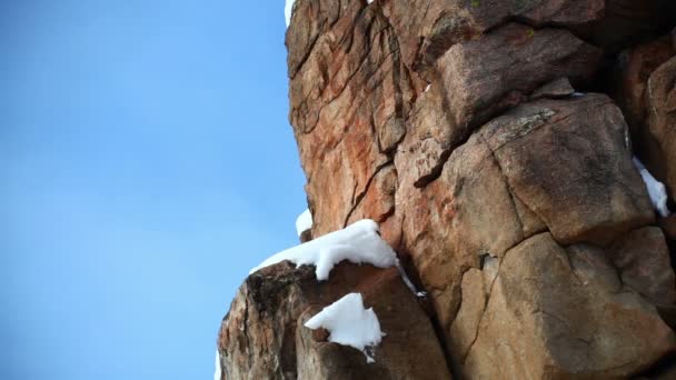 Snow on a tall red rock formation — Stock Video