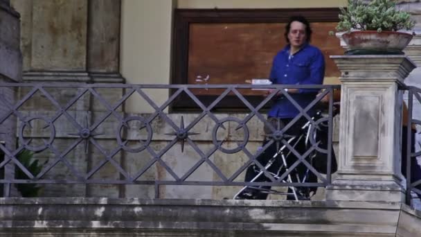 Een vrouw brengt zorgvuldig een kinderwagen met een kind neer een aantal trappen in Rome, Italië. — Stockvideo