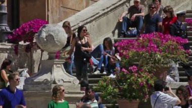 Üniformalı bir adam turistlerle dolu İspanyol Merdivenleri'nde yürüyor. Roma, İtalya.