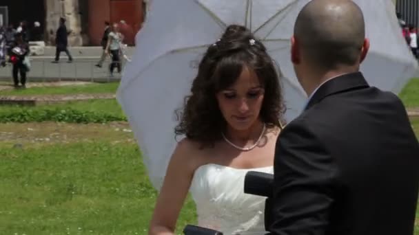 Sposa con un ombrello che parla con un fotografo — Video Stock