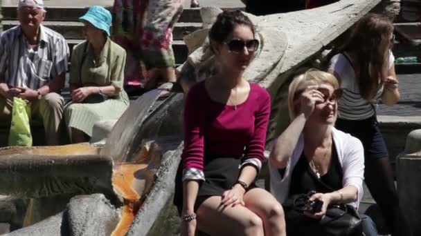 在意大利罗马的斯帕尼亚广场，两名妇女在喷泉旁休息. — 图库视频影像