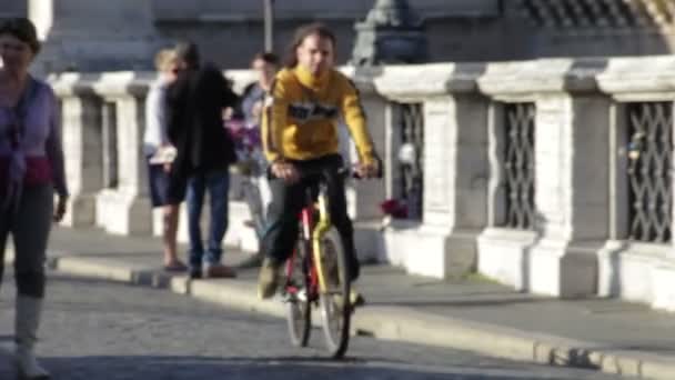 Bisikletli bir adam Roma, İtalya'daki Ponte Sant'Angelo'da turistlerin yanından geçiyor.. — Stok video
