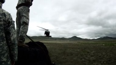 Yaklaşan Kara Şahin helikopterini bekleyen askerler