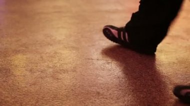 Loş ışıklı dans pistinde ayak işi yapan dansçılar