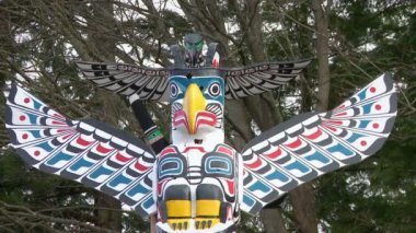 First Nation totem direğinin üstüne kuş figürü
