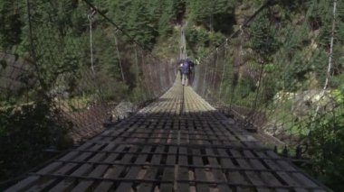 Nepal bir köprüyü geçtikten paketleri grubu.