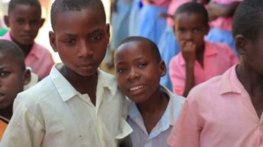 Kenya'da bir köyde bir bankta oturmuş çocuk.