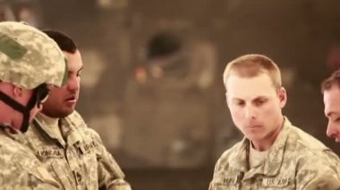 Bir grupta duran askerler hangarda konuşuyor