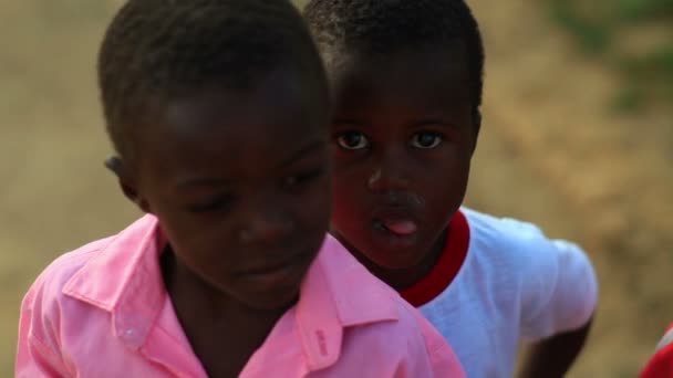 Kenyan boy hiding behind another boy — Stock Video