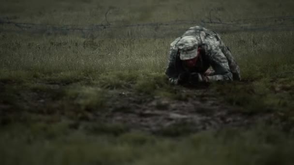 Soldat kriecht unter niedrigem Stacheldraht auf Ellbogen und Knien. — Stockvideo
