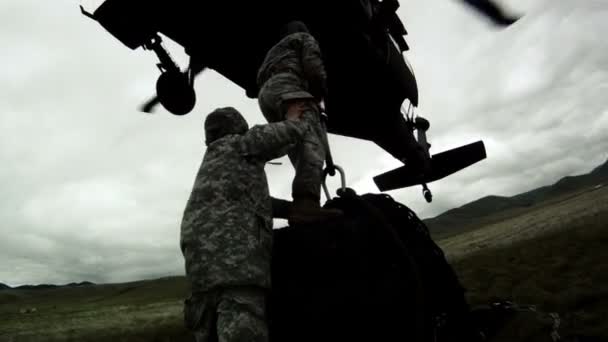 Pole żołnierzy przywiązując ładunek do helikoptera Black Hawk — Wideo stockowe