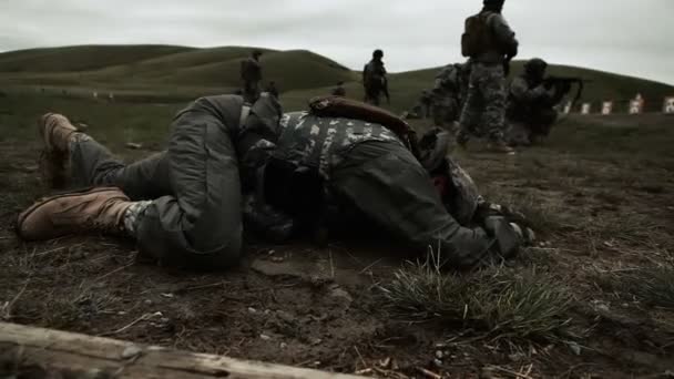 Soldado arrastrándose con campo de tiro en el fondo — Vídeos de Stock