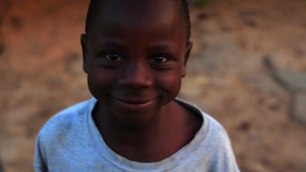 Un niño mirando, riendo y sonriendo a la cámara — Vídeo de stock