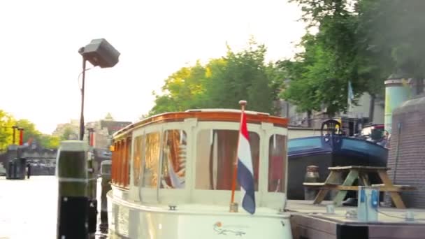 Husbåtar, människor och broar av en kanal i Amsterdam — Stockvideo