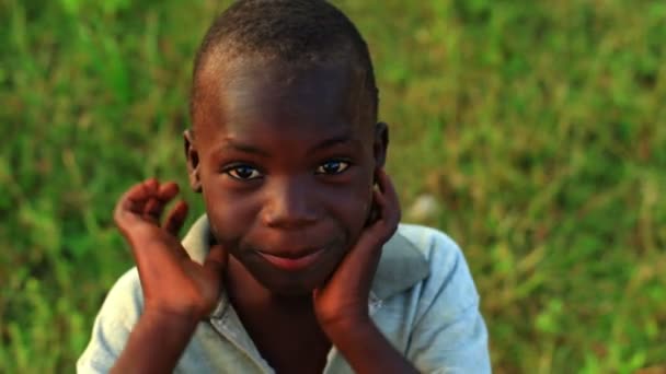 Кенийский мальчик с руками на бедрах смотрит в камеру — стоковое видео