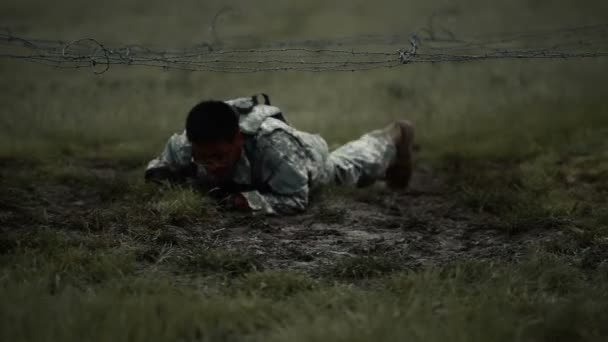 Soldado arrastrándose bajo cuerda en una carrera de obstáculos en un entrenamiento — Vídeo de stock