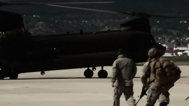 待っているCh-47チヌークヘリコプターに向かって歩く兵士 — ストック動画