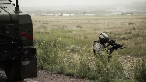 Soldado posicionado perto de Humvee na estrada lamacenta — Vídeo de Stock