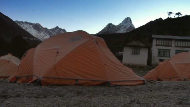 Orange tents and a building below Everest. — Stock Video