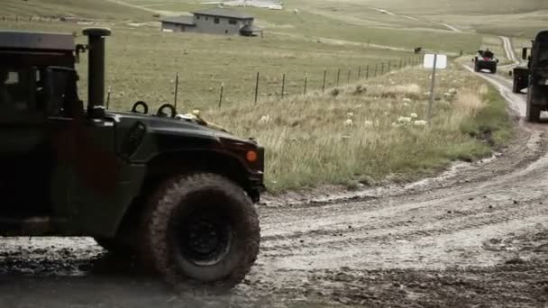 Convoy conduciendo por el camino fangoso, con fuego de armas — Vídeo de stock