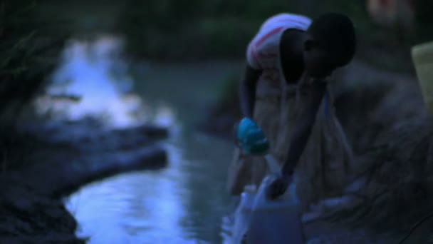 Un bambino che raccoglie acqua vicino a un villaggio in Kenya . — Video Stock