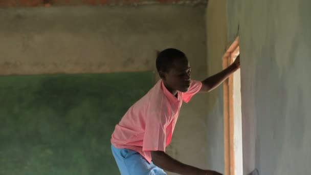 Pintar el interior de una escuela en un pueblo de Kenia . — Vídeo de stock
