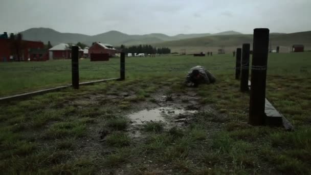 Muddied soldaten kruipen in een hindernissenparcours — Stockvideo