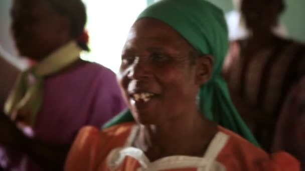 Seorang wanita mengenakan syal kepala bernyanyi dan menari selama ibadah di Kenya, Afrika — Stok Video