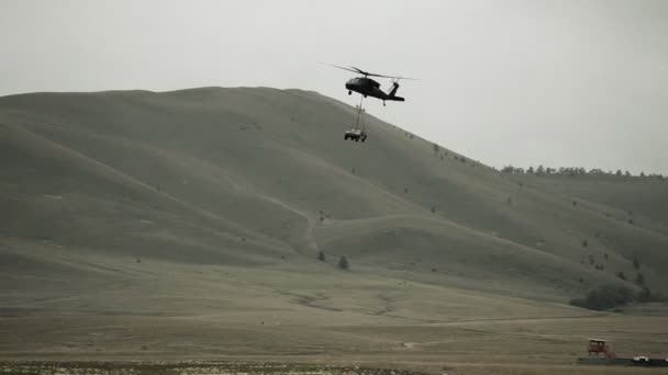 Black Hawk Hubschrauber, der einen Humvee schleppt — Stockvideo