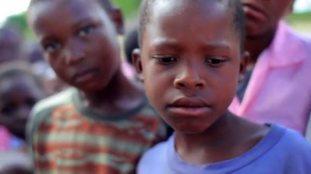 Keniaanse kinderen spelen in de buurt van een dorp. — Stockvideo