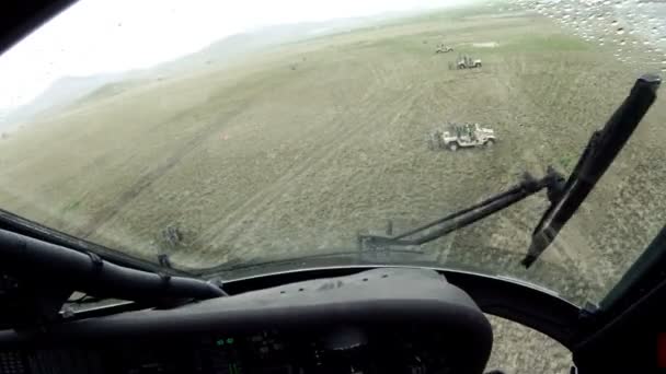 Чёрный ястреб пролетел над полем с Хаммерами . — стоковое видео