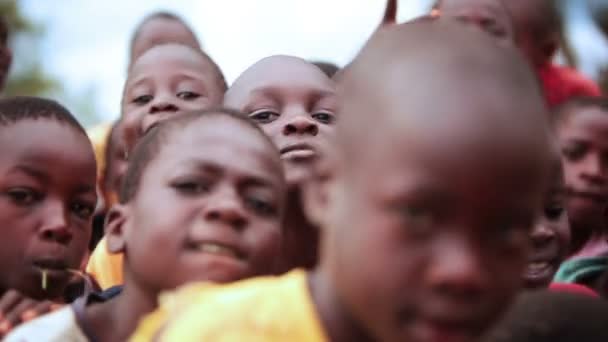 Junge jungs drängen sich gegenseitig, um in kenia, afrika für die kamera zu lächeln — Stockvideo
