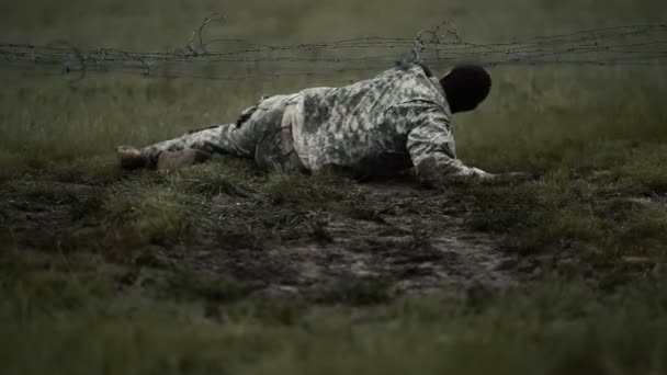 Soldat får sin kappa fastnat på tråd när kryper under den — Stockvideo