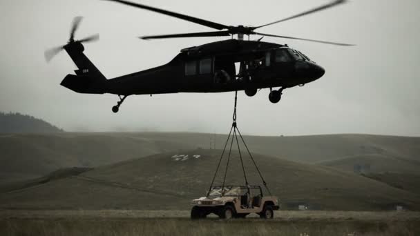 Hubschrauber zieht Humvee vom Feld — Stockvideo