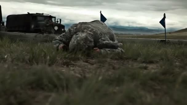 Солдат ползает по полю с инстуктором — стоковое видео