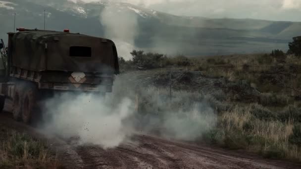 Un Humvee y un camión de transporte conduciendo mientras entrenan explosivos crean humo — Vídeo de stock