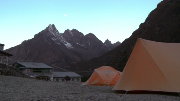 Tenten in de buurt van gebouwen in de schaduw van de Himalaya. — Stockvideo