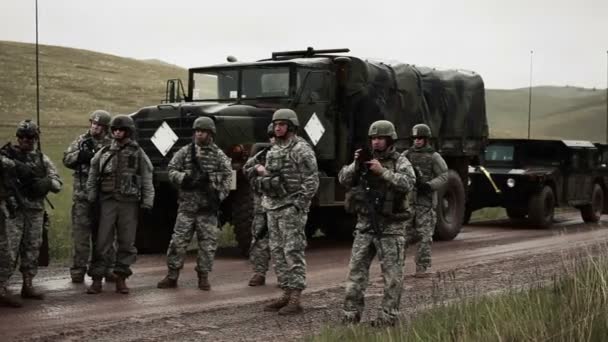 Soldaten en transportvoertuigen op modderige weg — Stockvideo