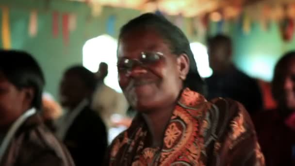 Ženy a muži zpívají a tančí na vnitřním společenském setkání v Keni v Africe — Stock video
