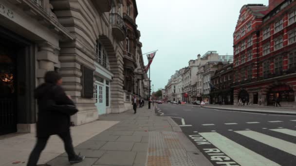 Auto guidare lungo la strada e la gente cammina attraverso il marciapiede a Londra — Video Stock