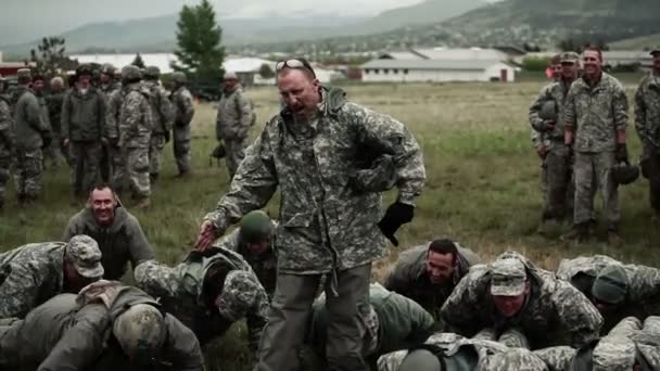 Soldat pose comme ceux qui l'entourent font des pompes — Video