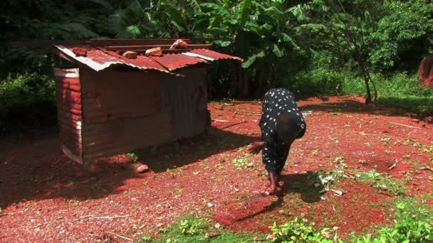 Désherbage fille sourde avec une petite cabane derrière elle — Video