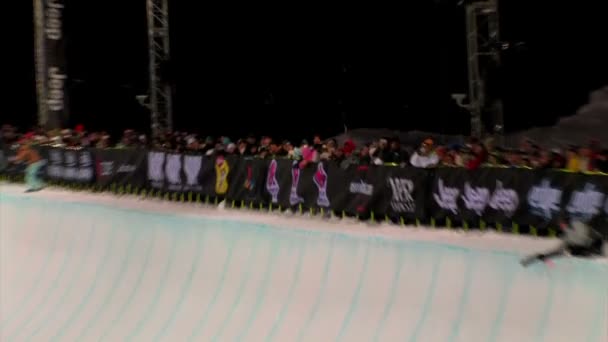 Snowboarder in a half-pipe at a competition. — Stock Video