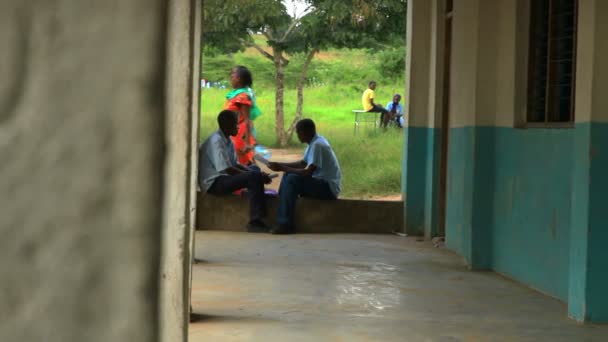 Dos estudiantes que estudian en un pasillo en una escuela en Kenia . — Vídeos de Stock