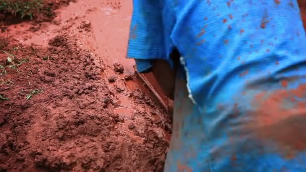 Un uomo modella mattoni; un altro uomo lo sostituisce per spalare argilla in Kenya, Africa — Video Stock