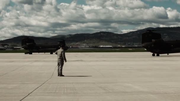 Soldaat staande in een landingszone met twee helikopters — Stockvideo