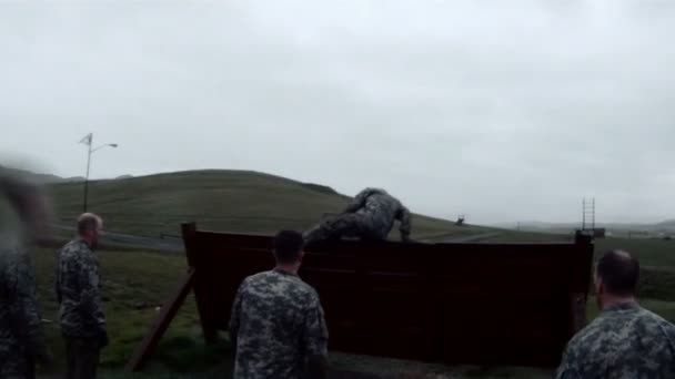 Солдат наблюдает, как другие идут через барьер — стоковое видео