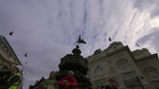 Niezidentyfikowana para siedzieć na statua Eros w Londynie — Wideo stockowe